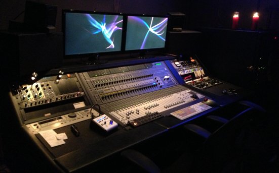 The OtherHand Recording control room: a mixing console and two monitors in low, warm light